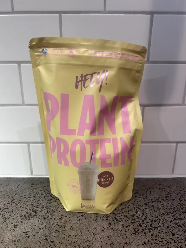 Heey Plant Protein Vanilla, gul påse med rosa text fotograferad framifrån