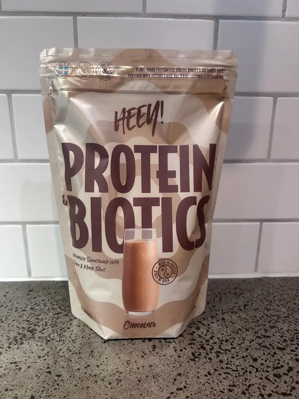 Heey Protein & Biotics Chocolate, beige påse med brun text